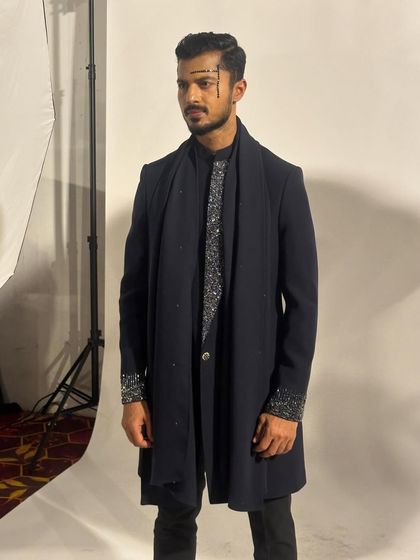 A backstage shot before the show, capturing the full details of the layered outfit and the makeup.