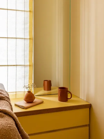 A detail shot of the yellow monochrome room, where even the side table and decor follow the sunny theme, creating a cohesive and cheerful vibe.