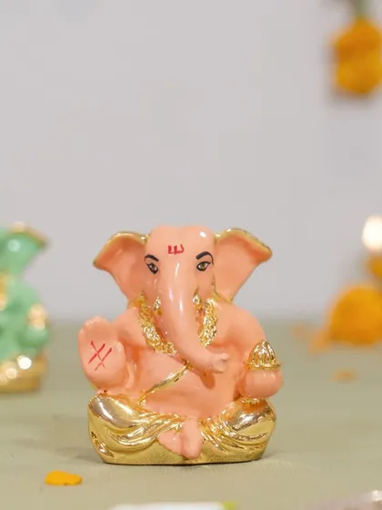 This charming pastel pink Ganesha idol with gold accents is perfect for adding a soft touch of devotion to your decor. It is a modern and sweet take on a traditional figure.