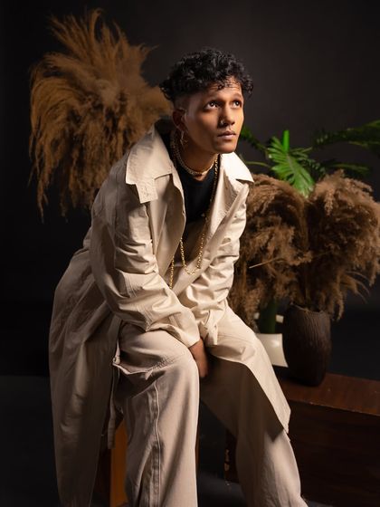 A seated portrait from my classy studio shoot, looking upwards with a thoughtful expression.