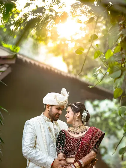 Bathed in a golden sun flare, this couple shares a romantic moment in a beautiful garden setting. This portrait perfectly blends natural light with genuine emotion to create a warm, timeless image.