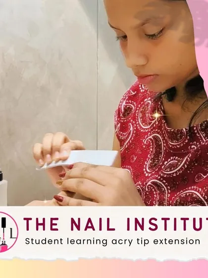 A student practices acry-tip extension application, focusing on blending the tip seamlessly with the natural nail.