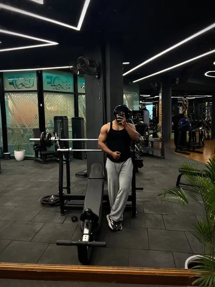 A mirror selfie capturing the spacious and well-equipped gym floor. You can see our bench press stations, cable machines, and the overall clean and modern layout of our facility.