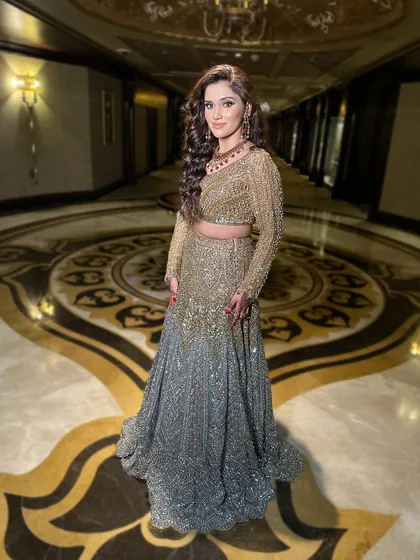 The full-length shot shows how the grand hairstyle balances a heavily embellished lehenga.