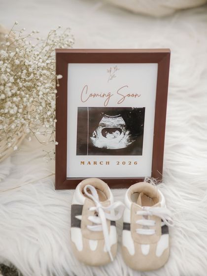 A beautiful flat-lay announcement. We framed the sonogram with the due date and placed it next to a tiny pair of baby shoes. It's a simple, stylish, and heartwarming way to share the big news.