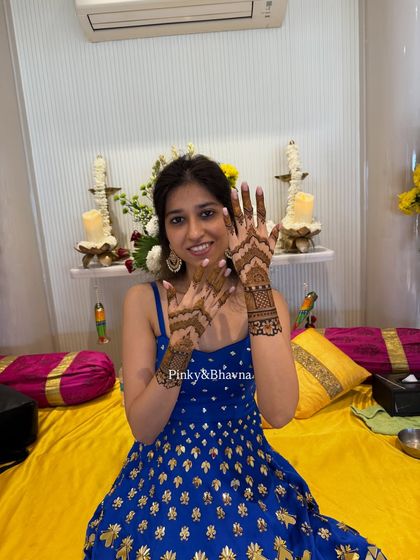 A happy client showing off her beautiful, minimal mehndi. The design is focused on the back of the hands, leaving the palms free, which is a popular choice for guests and bridesmaids.