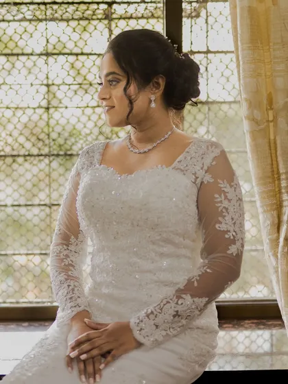 A serene portrait of the bride by the window, looking poised and elegant.