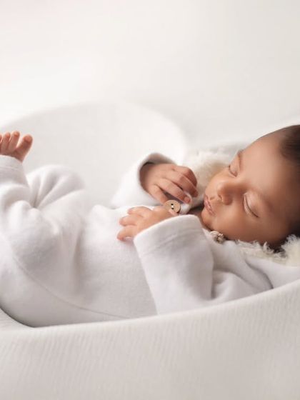 Nestled safely in a heart-shaped bowl, this baby is the picture of love. The all-white setup creates a pure and angelic feel.