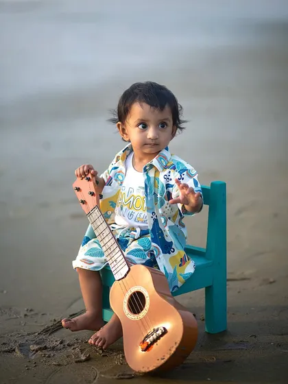 A thoughtful moment for our little beach bard. The soft evening light and the sound of the waves create a peaceful setting for a child's portrait.