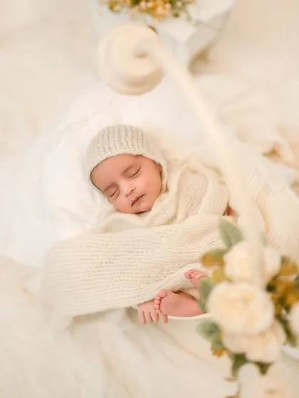 There is nothing more pure than a sleeping baby. In this close-up portrait, I focused on the soft textures of the hand-knitted wrap and bonnet, highlighting the baby's peaceful expression and tiny feet.