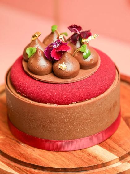 Our Chocolate Strawberry Entremet, a sophisticated dessert with rich chocolate, fresh strawberries, and a crunchy pistachio base.