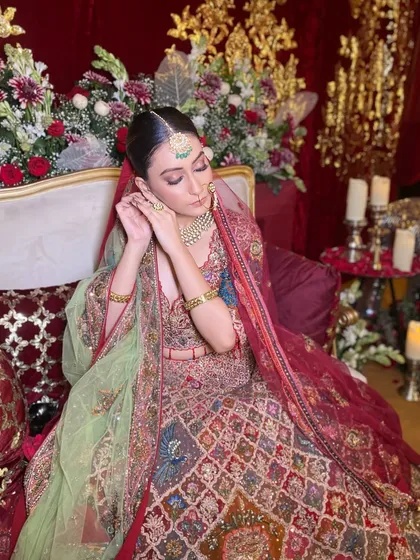 A candid moment of a bride adjusting her earring, showcasing the makeup from a different angle. This highlights the seamless blend of the foundation and the soft contour that defines her features.