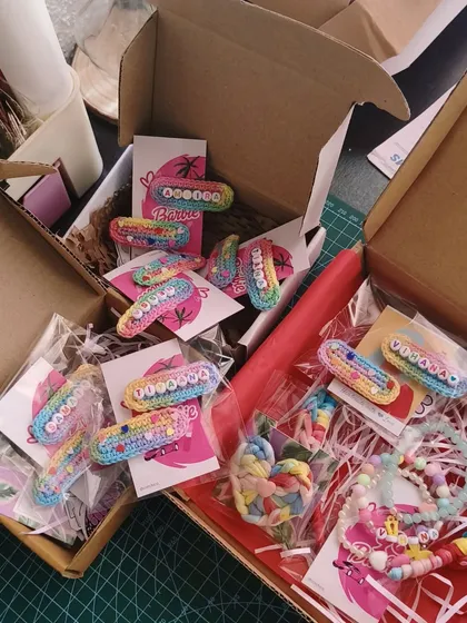 A box full of happiness! This is what a bulk order for birthday return favors looks like, with lots of personalized name clips and bracelets ready to be gifted.