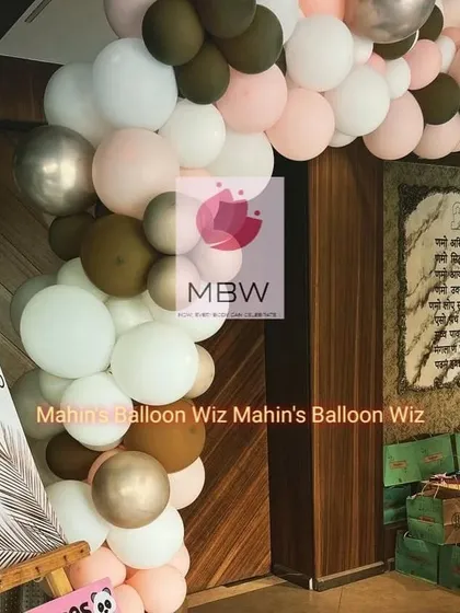 A chic and modern baby shower entrance. The balloon arch uses a sophisticated color palette of brown, white, pink, and silver, creating an elegant welcome for guests.