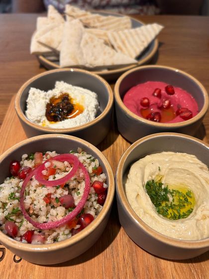 A colorful mezze platter from a restaurant in Mumbai. This overhead shot is perfect for showcasing the variety and freshness of the dips and salads.