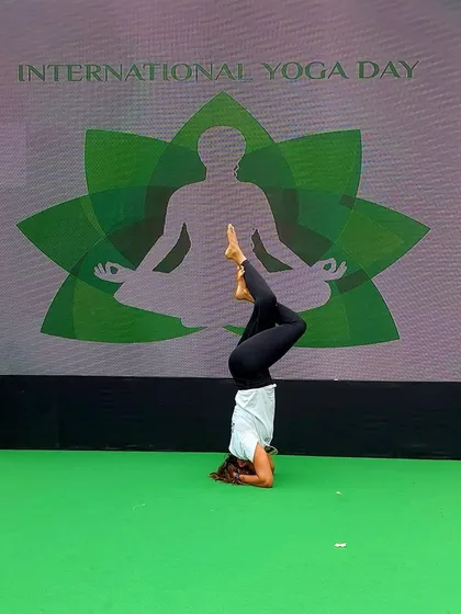 Demonstrating a variation of Sirsasana (headstand) on stage during the International Yoga Day event. My goal was to show that with practice, we can find stability and grace even when our world is turned upside down.