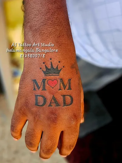 Simple, bold, and full of meaning. This "Mom Dad" tattoo on the hand with a crown and heart is one of my most popular requests, a permanent tribute to the most important people in our lives.
