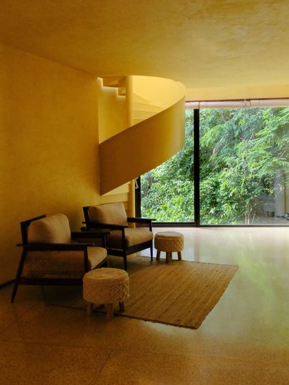 The Banyan Suite's living area, showcasing the blend of modern furniture, natural light, and unique architectural details.