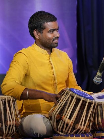 A percussionist provides rhythmic support on the tabla during the Raag Hamsadhwani performance.