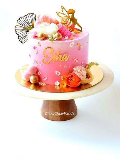 Another angle of the pink angel cake, showing the personalized name and fan decoration.