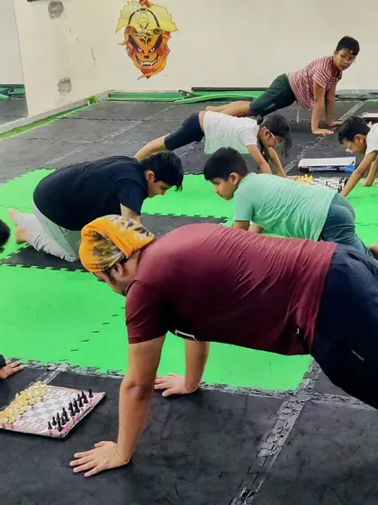 A unique training method: planking while playing chess. This builds core strength and endurance while forcing the mind to stay sharp and focused under physical stress.
