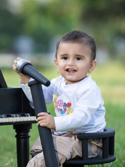 A happy moment from the outdoor music session, with the little one smiling brightly.
