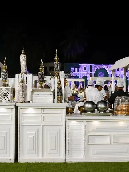 A clean and chic all-white theme for an outdoor wedding reception. This setup includes live cooking stations where my chefs prepare fresh meals for guests in a stylish, coordinated environment.