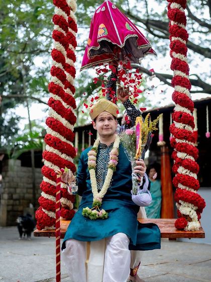 The groom, Patrick, sits on the floral swing during the 'Kashi Yatra' ritual of his South Indian wedding to Sunayana.