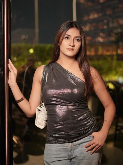 A sweet and simple portrait from a night out, wearing a shimmery one-shoulder top and jeans.