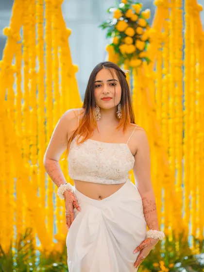A confident front-facing pose in the white Haldi outfit. This shot clearly shows the delicate top and modern draped skirt.