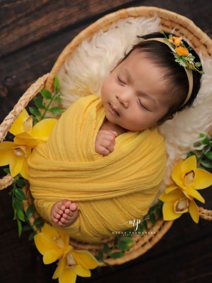 A slightly different overhead view, showing the baby's tiny hands and feet tucked into the swaddle.
