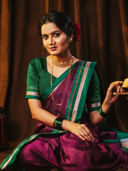 A classic portrait in a traditional Khan saree. The warm lighting and brown backdrop create a vintage, earthy feel.