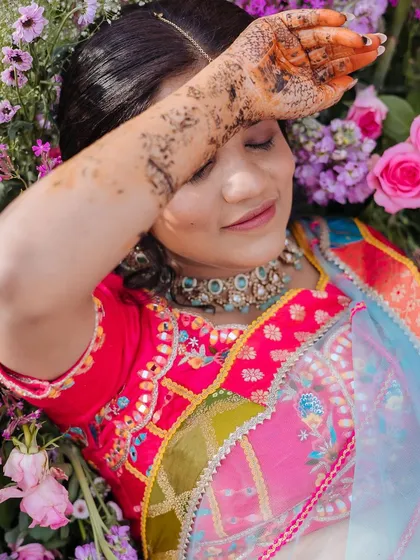A creative portrait of the bride lying in a bed of flowers, a dreamy and artistic shot.
