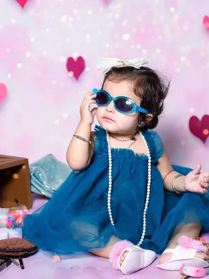 This little one is a natural model, posing with her sunglasses. These fun, playful sessions are perfect for capturing a child's confident spirit.