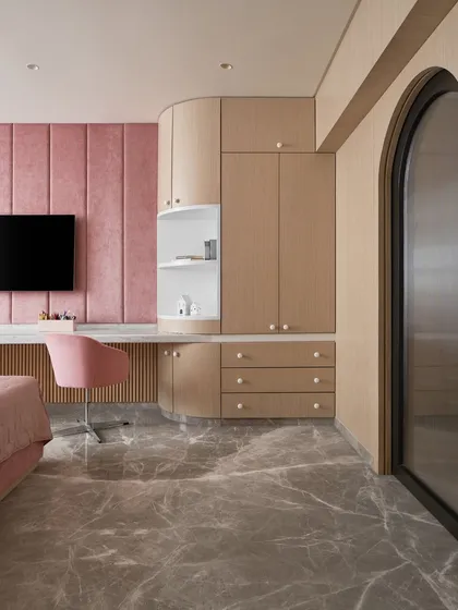 For this kid's bedroom, I designed a curved wardrobe and desk unit to soften the room's corners and maximize space. The custom cabinetry provides ample storage while the continuous surface creates a playful yet sophisticated built-in feature.