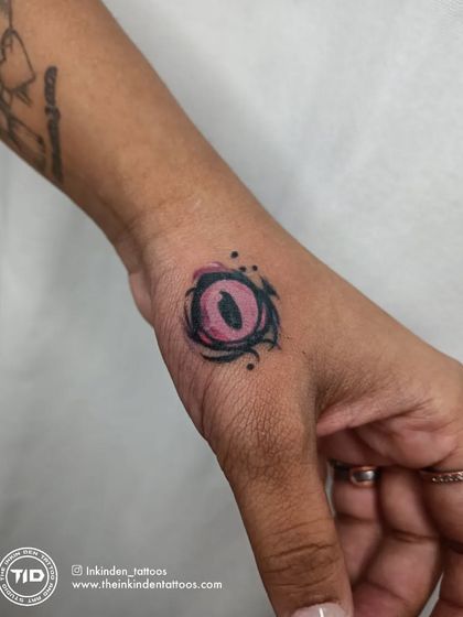 The Valorant 'Reyna' ability icon, an eye, tattooed on the hand.