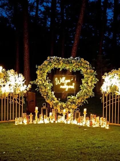 A direct view of the heart-shaped floral wreath against the dark woods. This element serves as the perfect photo backdrop, combining natural florals with modern lighting for a truly unique look.