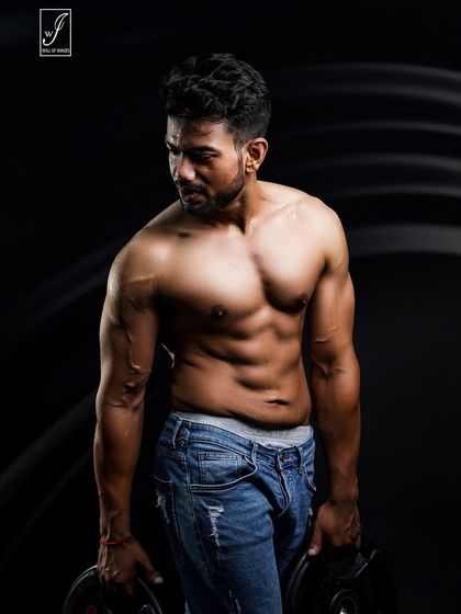 A simple but effective shot using two weight plates. Holding the weights engages the muscles in the arms and shoulders, showing practical strength in a controlled studio environment.