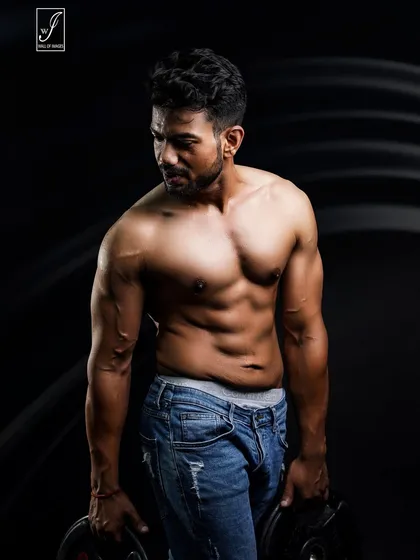 A simple but effective shot using two weight plates. Holding the weights engages the muscles in the arms and shoulders, showing practical strength in a controlled studio environment.