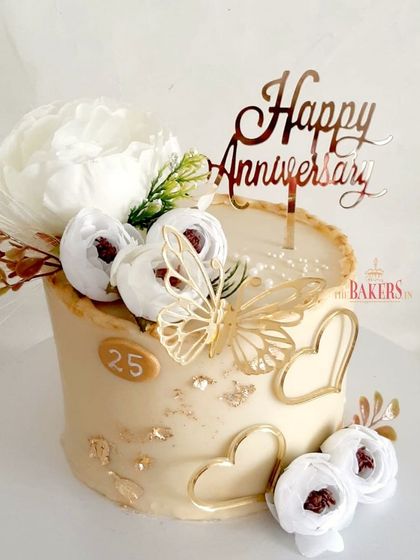 A very pretty 25th-anniversary cake in white and gold. This no-fondant beauty is decorated with white peonies, gold butterflies, and heart details, making it an elegant and romantic choice.