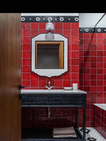 This vanity concept uses bold red subway tiles and a custom-framed mirror to create a vibrant and energetic bathroom space. The black vanity provides a striking contrast.