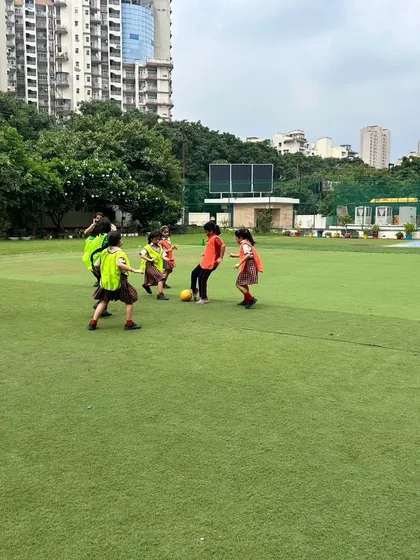 A wide view of the girls' football match in progress on our well-maintained artificial turf. Our excellent facilities provide the perfect setting for students to hone their athletic abilities.