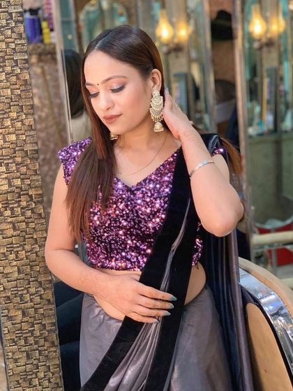 A modern party look with a sequin blouse and a satin saree. The makeup is soft and bronzed, perfect for a cocktail party or evening event.