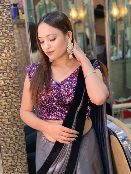 A modern party look with a sequin blouse and a satin saree. The makeup is soft and bronzed, perfect for a cocktail party or evening event.