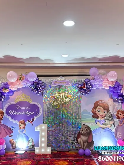 A full-stage Princess Sofia theme for a grand first birthday party. The setup includes multiple backdrops and character cutouts to create a royal scene.