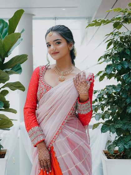 A happy bride-to-be in her custom engagement lehenga. The full-sleeved red blouse with silver embroidery adds a touch of glamour to the ensemble.