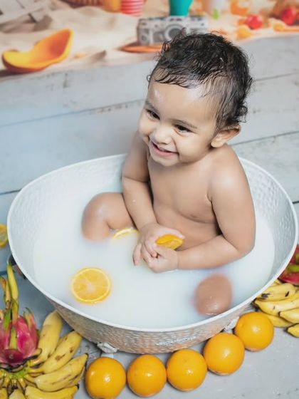A close-up of the happy baby enjoying his fruit-filled milk bath.