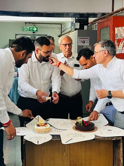 A senior colleague shares a piece of cake during the celebration, a gesture of mentorship and affection.