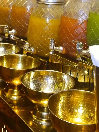 A close-up of our chaat station's drink dispensers and traditional hammered-brass bowls. This highlights our commitment to authentic presentation and the small details that create a luxurious experience.