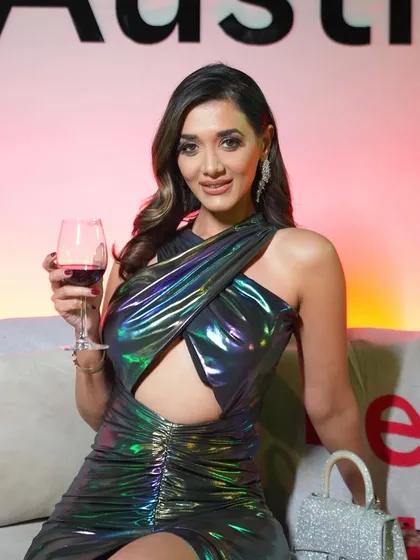 The client enjoying a glass of wine, her makeup looking flawless under the event lighting.